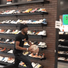 a man wearing a black shirt that says supreme holds a basketball
