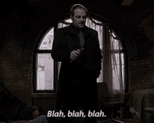 a man in a suit and tie is holding a knife and saying blah blah blah ..