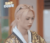 a person wearing a kimono and sunglasses with the words sk2 code on the bottom right