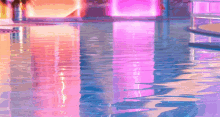 a swimming pool with pink and blue lights reflected in it