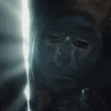 a close up of a person 's face in the dark with a light behind it