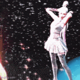 a woman in a white dress is dancing in front of a planet