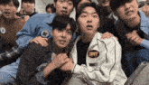 a group of young men are posing for a picture and one of them is wearing a jacket that says exit