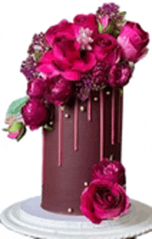 a chocolate cake with pink flowers on top is on a white plate .