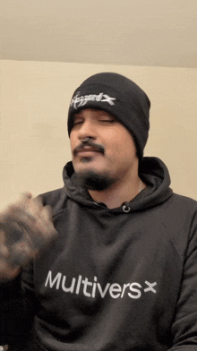 a man wearing a beanie and a hoodie that says " multivers "