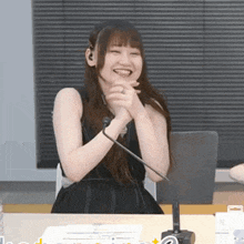 a woman is sitting at a table with a microphone in front of her .