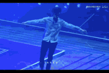 a man in a blue shirt is dancing on a stage with the word tarro on the bottom