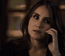 a woman with a ring on her finger is talking on her cell phone