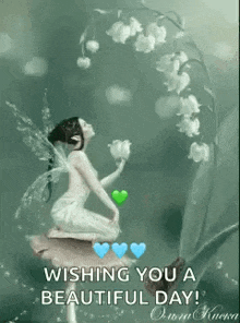 a fairy is sitting on a rock next to a lily of the valley and holding a flower .