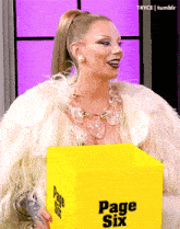 a woman is holding a yellow box that says page six on it