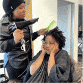 a woman blow drying another woman 's hair with a brush