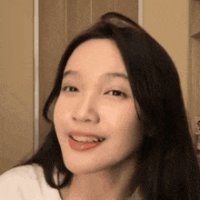 a close up of a woman 's face with long hair and a smile on her face .