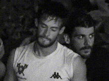 two men are standing next to each other in a black and white photo .