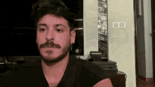 a man with a beard and mustache is wearing earrings