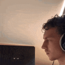 a man wearing headphones is looking at a computer screen