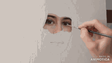 a person is painting a woman 's face on a canvas with the words made in animatica below it