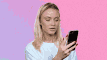 a woman is holding a cell phone and making a funny face