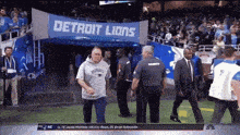 a man in a patriots sweatshirt walks into a detroit lions entrance