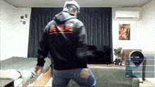 a man in a black hoodie with chinese writing on the back is dancing in a living room