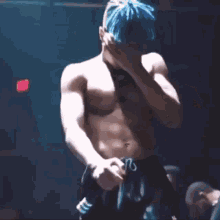 a shirtless man with blue hair and a necklace around his neck .