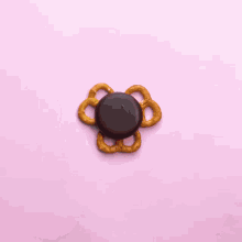 pretzels with chocolate and m & m 's on them on a pink surface