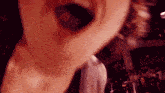 a close up of a person 's mouth with a crowd of people in the background