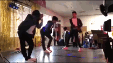 a group of people are dancing in a room with gold tinsel hanging from the ceiling