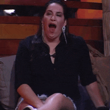 a woman sitting on a couch with her mouth wide open