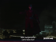 a sign that says mari bergembira let 's have fun with a city in the background
