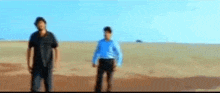 a blurry picture of two people standing in a desert .