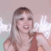 a woman is smiling in front of a neon sign that says " bubbly "