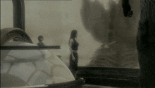 a woman in a black dress stands in front of a globe