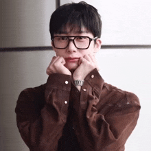 a young man wearing glasses and a watch makes a face