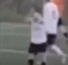 a blurry picture of a person kicking a soccer ball on a field