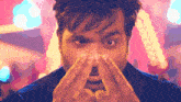a close up of a man 's face with his hands on his nose
