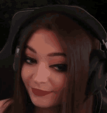 a close up of a woman wearing headphones and smiling .
