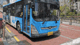 a blue and white bus has a license plate that says hy1702