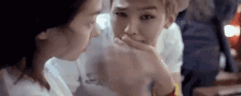 a man is kissing a woman 's hand while sitting next to her .