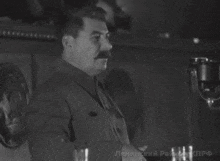 a man with a mustache is giving a speech in a black and white photo with russian writing on it