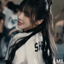 a girl wearing a white shirt that says sh on it