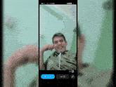 a phone screen shows a man wearing headphones and smiling with a blue button that says ' share ' on it