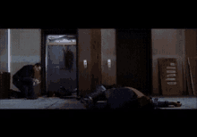 a man is kneeling down in front of an elevator with a sign that says ' a ' on it