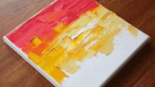 a red and yellow painting on a canvas