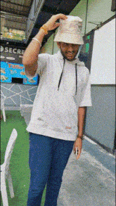 a man wearing a white shirt and a bucket hat is standing in front of a secre restaurant