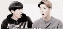 two young men are standing next to each other with their mouths open and making funny faces .