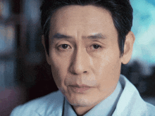 a man in a white coat looks at the camera