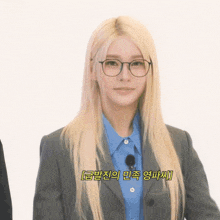 a woman with long blonde hair wearing glasses and a blue shirt with korean writing