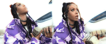 a woman in a purple camo jacket is holding a large stack of money