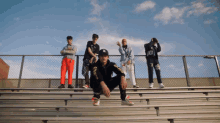 a group of young men are posing for a photo on a bleacher