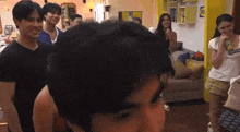 a group of people are standing around a man in a room .